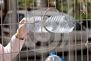 Hand throwing a plastic bottle into a container for separate garbage collection in Israel