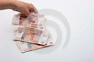 Hand throws 5000 rubles banknotes on a white background