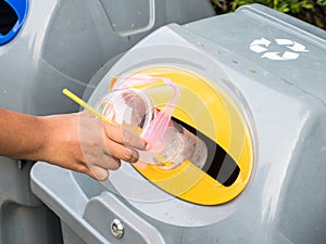 Hand throws away waste material into trash photo