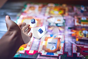 Hand throws the dice on the background of Board games