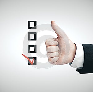 Hand with thumbs up sign and drawing check box