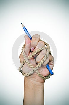 Hand tied with rope holding a pencil