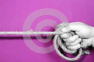 Hand tied with rope on purple background