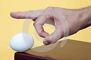 Hand about to flick an egg photo