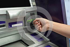 Hand about to insert card to ATM machine ready to withdraw or transfer money