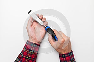 Hand tool chisel on a white background in a man& x27;s hand, top view. Craftsman in a plaid shirt holds a carpentry hand