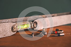 Hand tools for building and construction mixed with screwdriver bits, vintage spirit level or bubble level on a wooden background