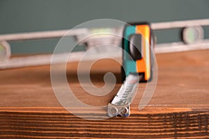 Hand tools for building and construction, vintage spirit level or bubble level and tape measure on a wooden background