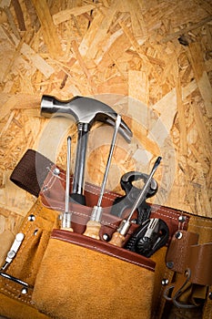 Hand Tools In Tool Belt On plate Of Pressed Wood