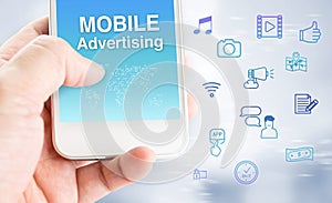 Hand touch mobile phone with mobile advertising word with feature icon at blurred grey background, Digital marketing business con