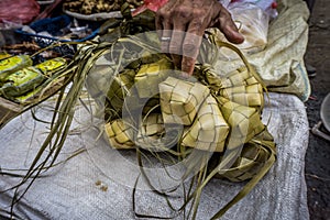 A hand touch rice wraped with coconut leaf with diamond shape in traditional market Bogor Indonesia