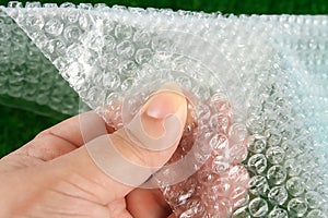 The hand touches bubble wrap. The concept of touch, tactility, feelings