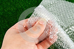 The hand touches bubble wrap. The concept of touch, tactility, feelings