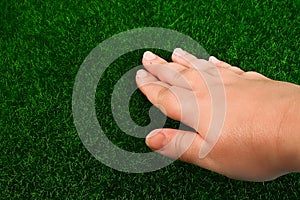 Hand touches the grass lawn. The concept touch, tactility, feelings