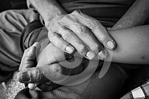 Hand touches and holds an old man wrinkled photo