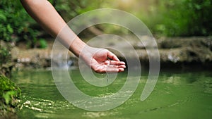 hand touches water in the pond