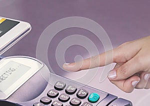 Hand touching card reader with purple background