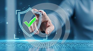 Hand touching digital shield with green checkmark on blue binary code background