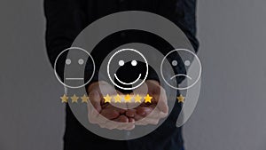 Hand touching and doing mark to select smiley face icon for evaluate product and service.