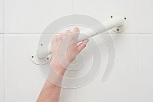 Hand touching handle in bath tub