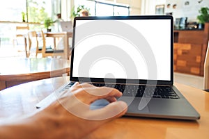 A hand touching on laptop computer touchpad with blank white desktop screen on the table