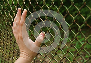 Hand touching a metal grille