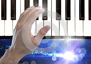 Hand Touching Piano keys with sparkling lights