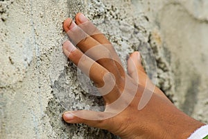 a hand touching stone wall