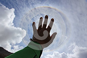 Hand touching the sun. Fantastic beautiful sun halo phenomenon