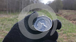 Hand of a Tourist in Gloves Holding a Pocket Compass Outdoors