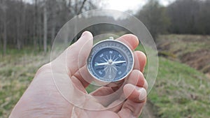 Hand of a Tourist Holding a Pocket Compass Outdoors