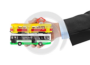 Hand with toy bus and tram