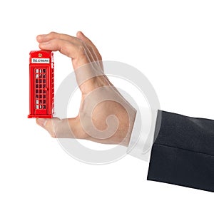 Hand with toy red phone booth of London