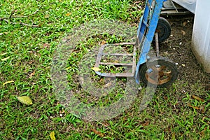 Hand truck on green grass in the garden beside a pile waste with plastic trash can, environment concepts