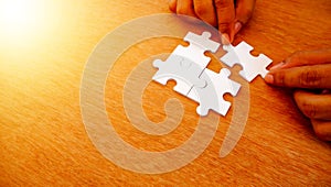 Hand try to put white puzzle jigsaw and lay the jigsaw on missing area