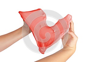 Hand trying to form heart shape from red slime toy