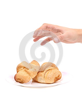 Hand trying to grab croissants.