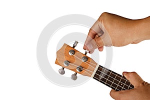 Hand tuning ukulele on white