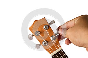 Hand tuning ukulele on white