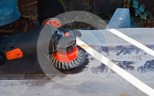 Hand with a turbine removes rust from metal. man using angle grinder
