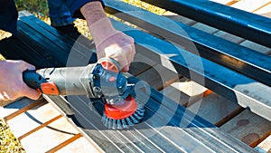 Hand with a turbine removes rust from metal. man using angle grinder