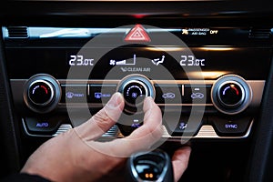 Hand turn on air conditioner dial button in a korean modern luxury car