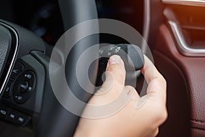 Hand turn on light switch inside car. Safety transportation concept