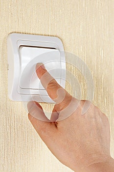 Hand turn off the light switch on the wall