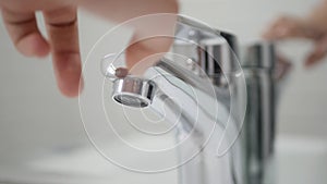 Hand Turn Off the Tap Water on Sink, Faucet, Woman Stops Wasting Water, Inundation, Running Water for Washing in Bathroom