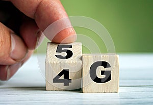 Hand turn wooden block and change technology word 4G to 5G. Network future. High speed of mobile internet