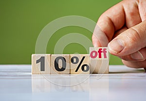 The hand turn wooden block and change word to 10% off. Sale background concept