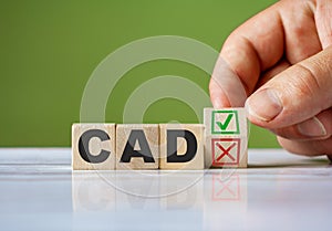 The hand turn wooden block with red reject X and green confirm tick as change concept of CAD. Word CAD capital adequacy directive