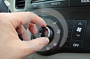 Hand turning a car Air Conditioning Heater knob