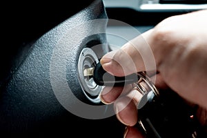 Turning car key in the key hole to start the car engine photo